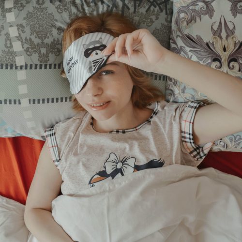 meisje in bed met oogmasker op