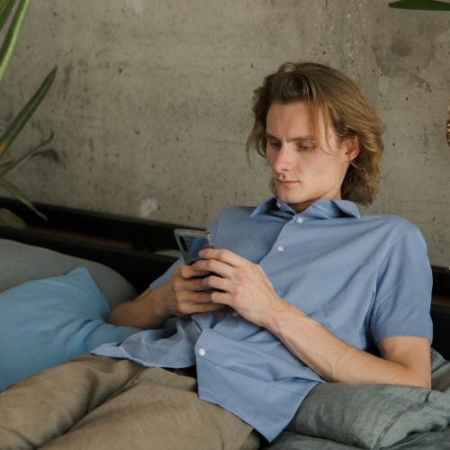 man met telefoon lui op de bank