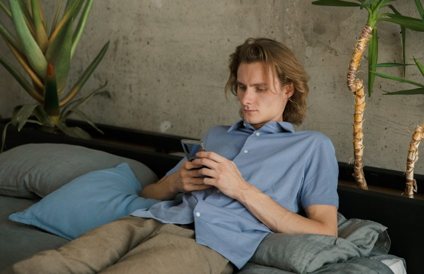 man met telefoon lui op de bank