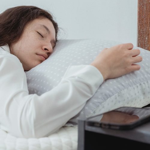 vrouw in bed naast wekker