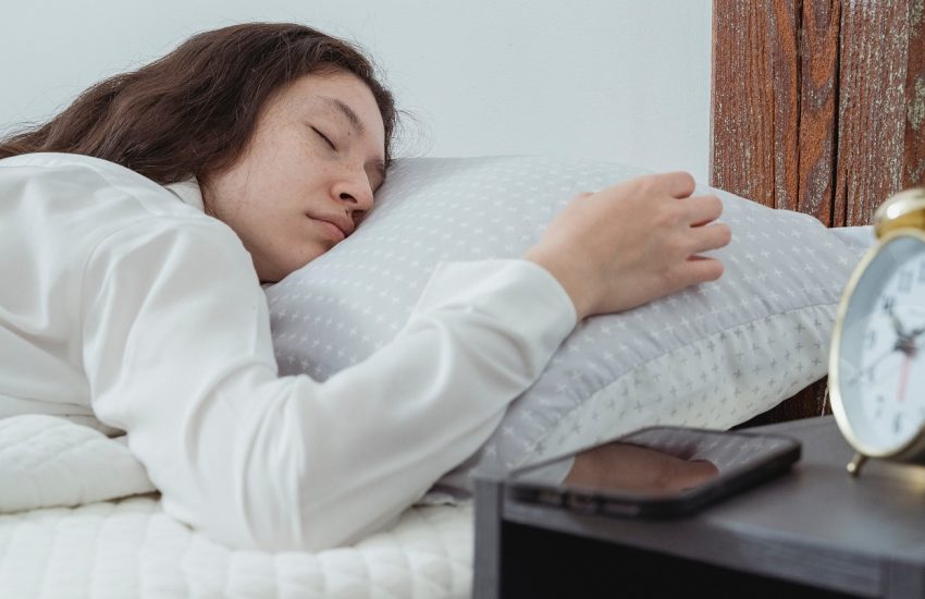 vrouw in bed naast wekker