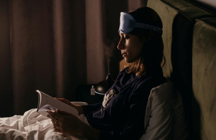 Vrouw met slaapmasker in bed